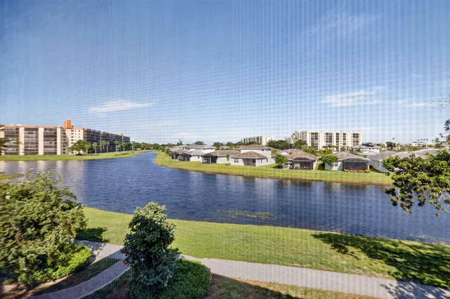 a view of a city with lawn chairs and large trees