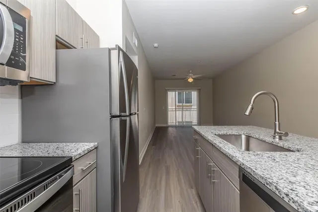 a kitchen with stainless steel appliances granite countertop a sink stove and refrigerator