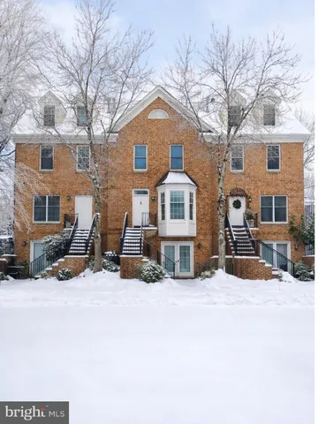 a front view of a house with a yard covered in snow
