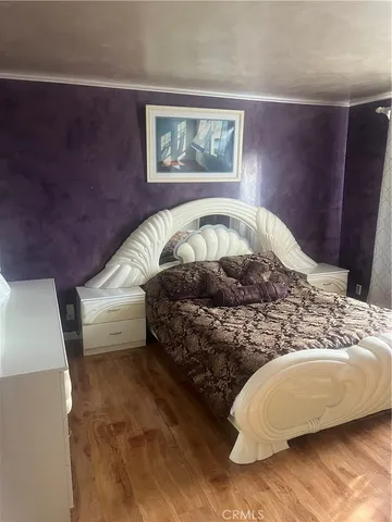 a bedroom with a bed and a painting on the wall