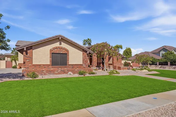 a front view of a house with a yard and green space