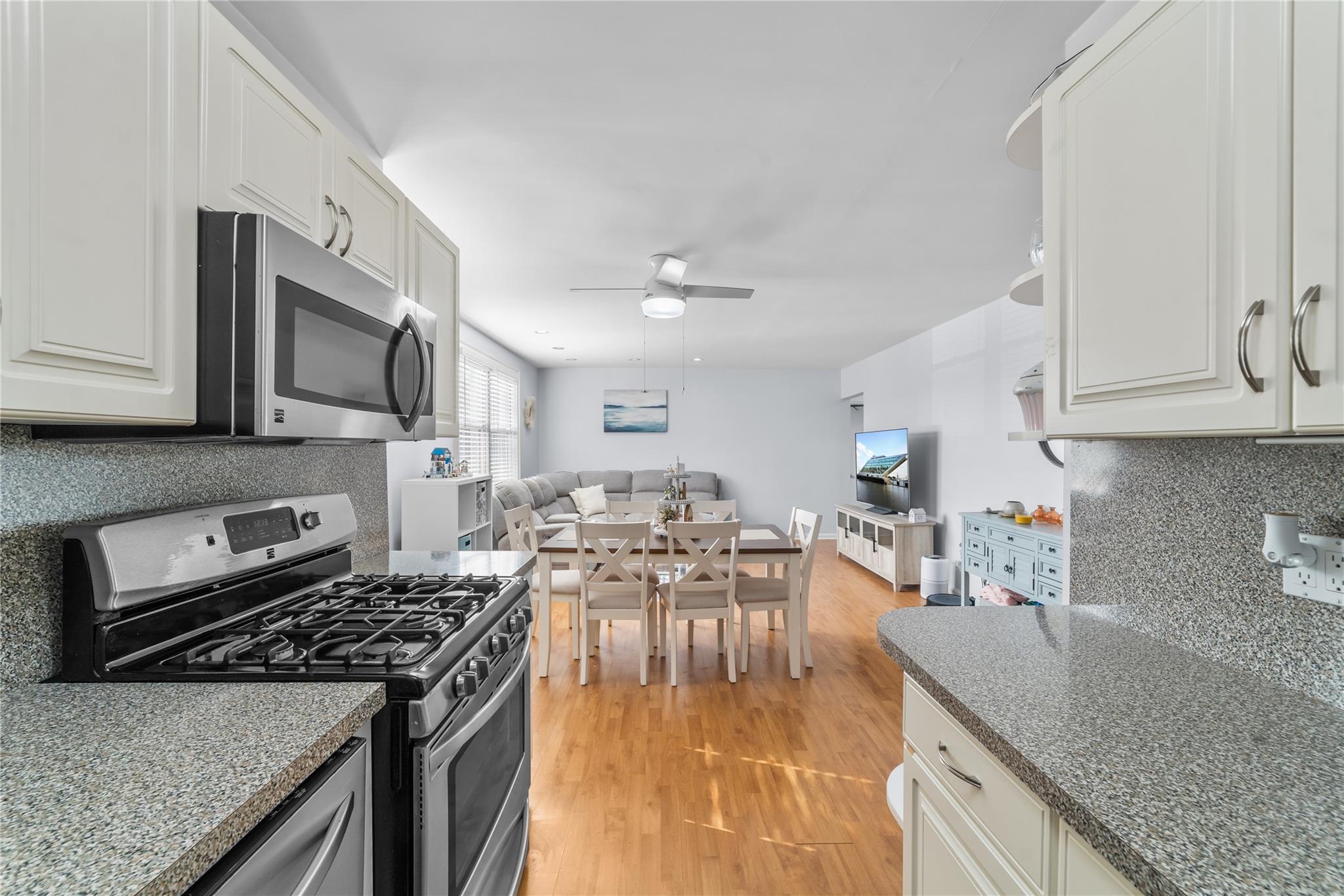 7 Bryant Crescent, Unit 2G White Plains, NY 10605 - Photo 1 of 1 Kitchen featuring tasteful backsplash, light wood-type flooring, ceiling fan, stainless steel appliances, and white cabinets