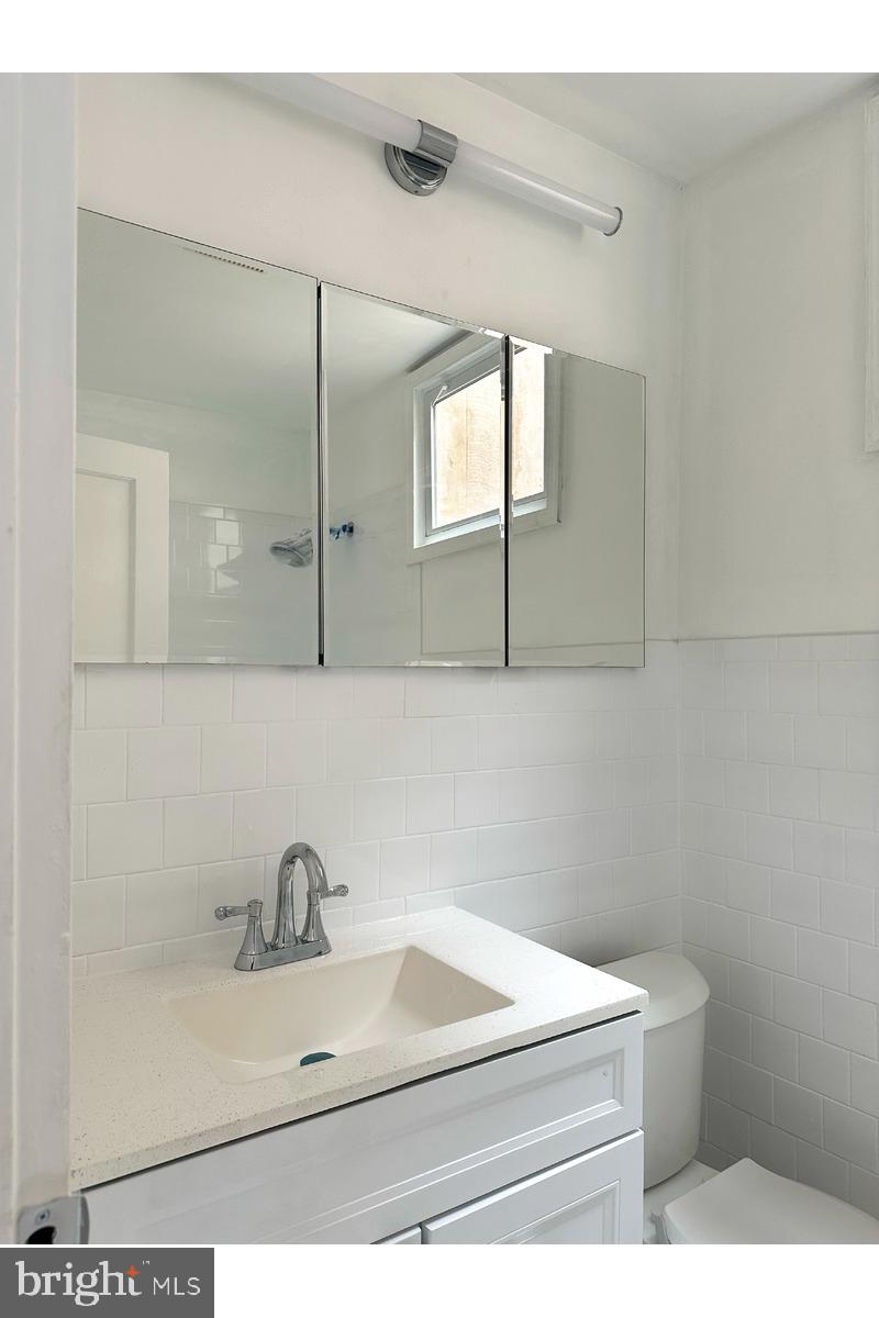 1280 16th Street Northeast Washington, DC 20002 - Photo 9 of 33 a bathroom with a sink a mirror and vanity