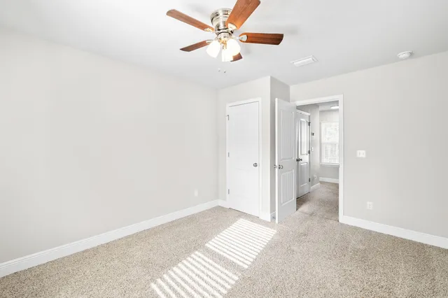 a view of a room with a stylish ceiling fan and entryway