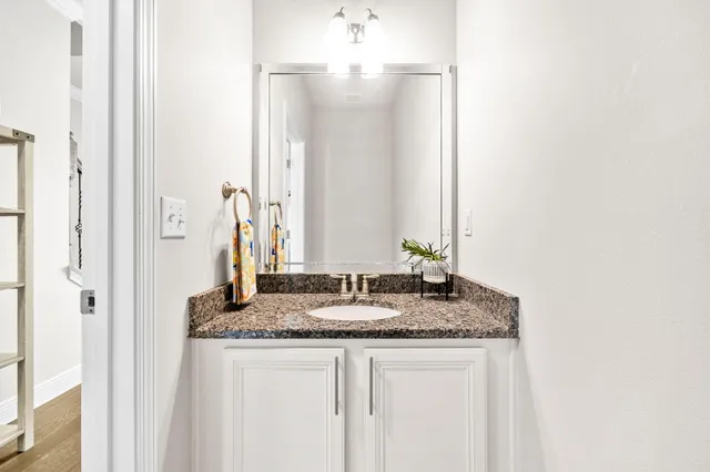 a bathroom with a granite countertop sink and a mirror