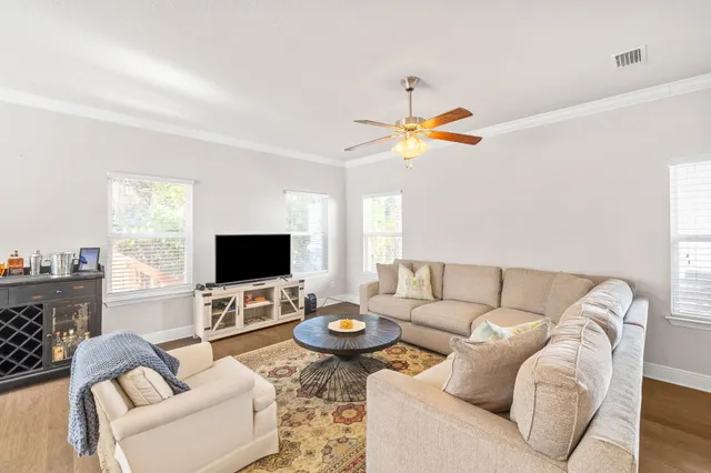 a living room with furniture a chandelier and a flat screen tv