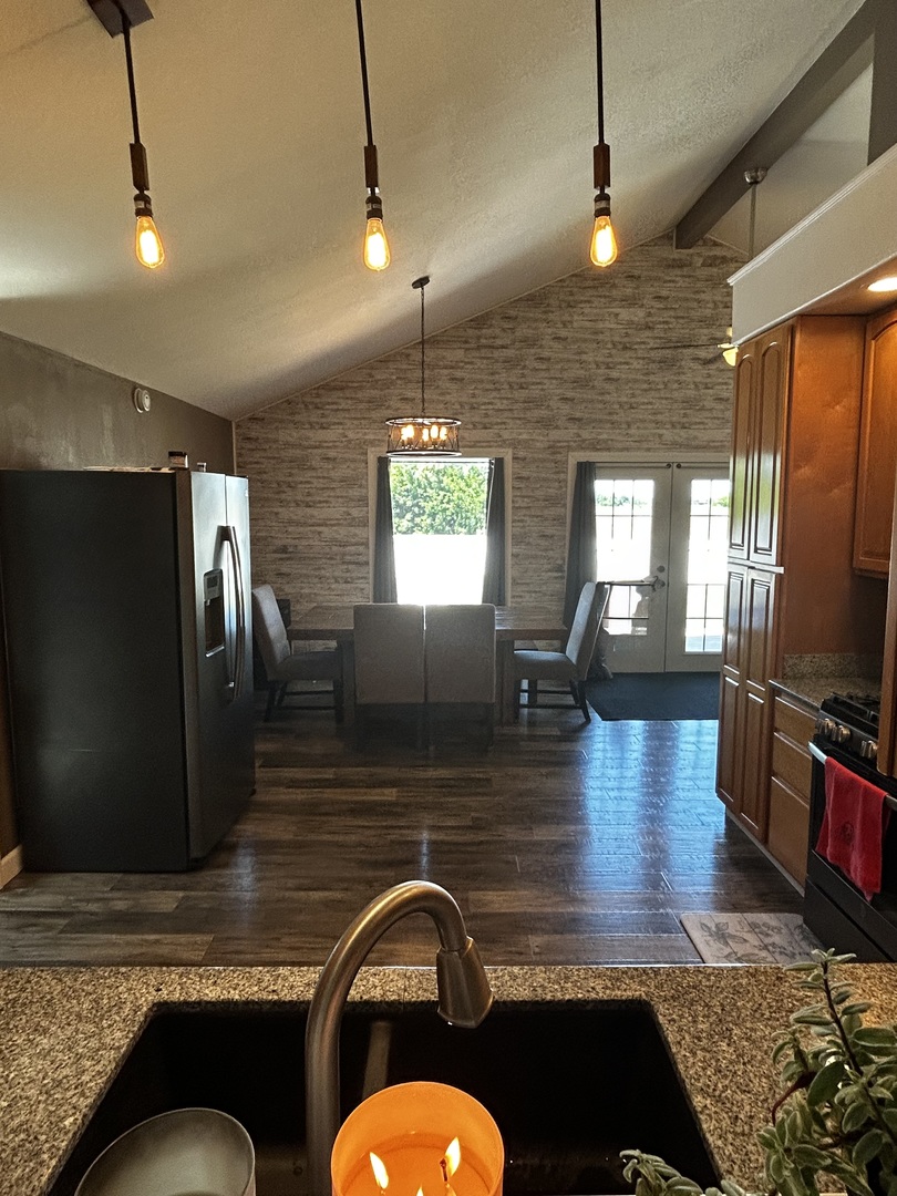 12795 Lawrence Road Sterling, IL 61081 - Photo 21 of 42 a kitchen with stainless steel appliances granite countertop a stove a sink dishwasher a refrigerator wooden floor and a dining table with chairs