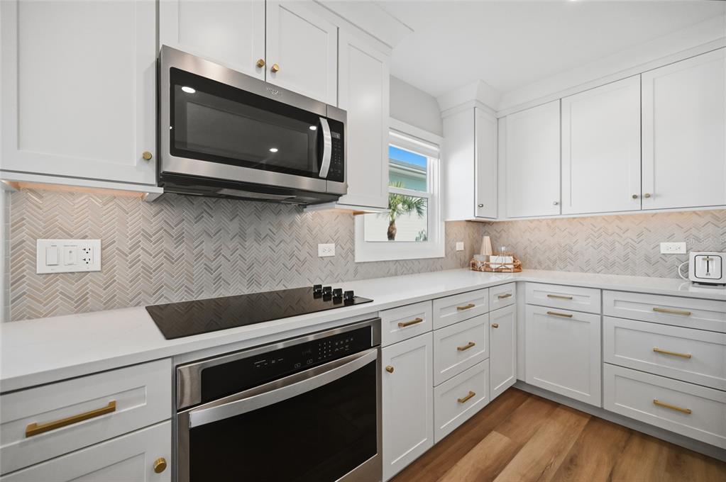 380 Gulf Boulevard, Unit 1 Boca Grande, FL 33921 - Photo 15 of 35 a kitchen with cabinets stainless steel appliances and wooden floor