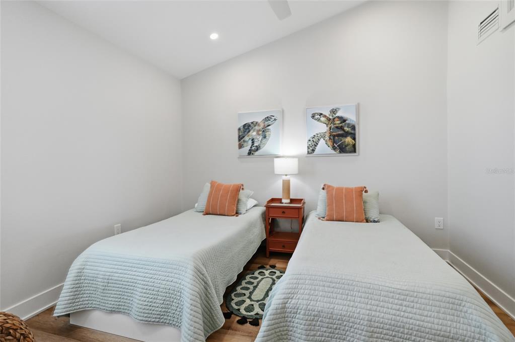 380 Gulf Boulevard, Unit 1 Boca Grande, FL 33921 - Photo 25 of 35 a bedroom with a bed and a lamp with wooden floor