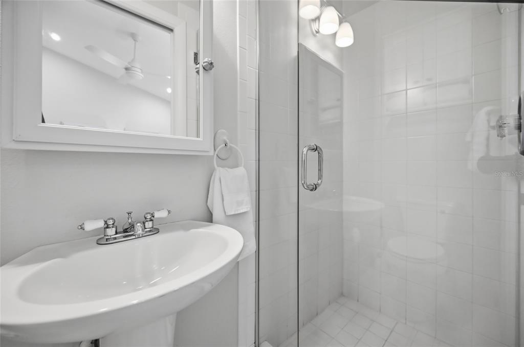 380 Gulf Boulevard, Unit 1 Boca Grande, FL 33921 - Photo 30 of 35 a bathroom with a sink a shower and a mirror