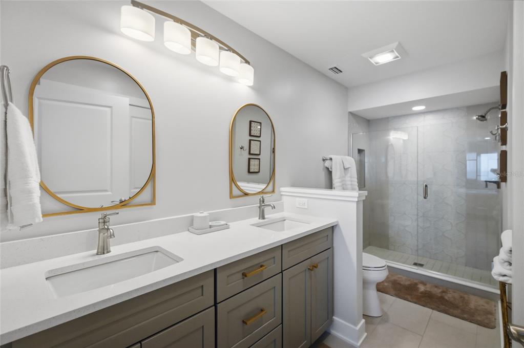 380 Gulf Boulevard, Unit 1 Boca Grande, FL 33921 - Photo 32 of 35 a bathroom with a double vanity sink mirror and shower