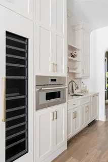 a kitchen with stainless steel appliances a stove and white cabinets