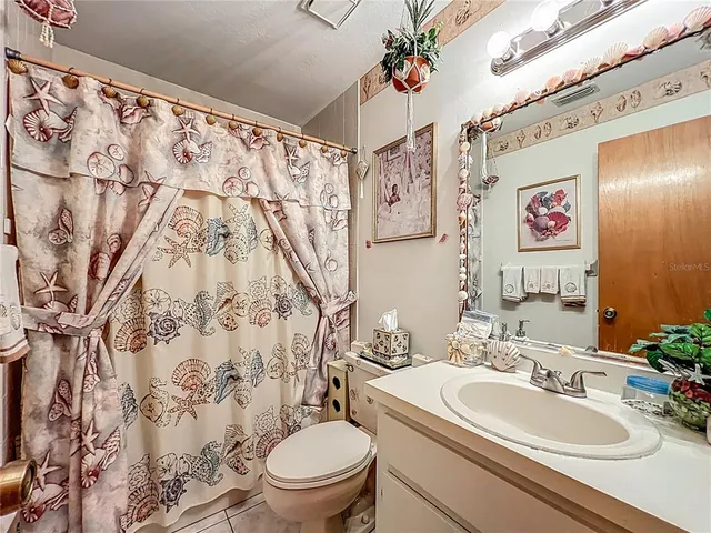 a white toilet sitting next to a bathroom sink and a mirror