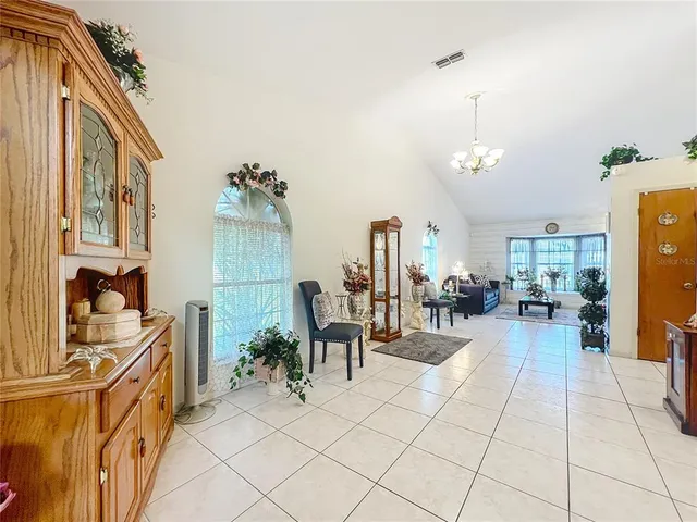 a view of a dining room with furniture a chandelier and wooden floor