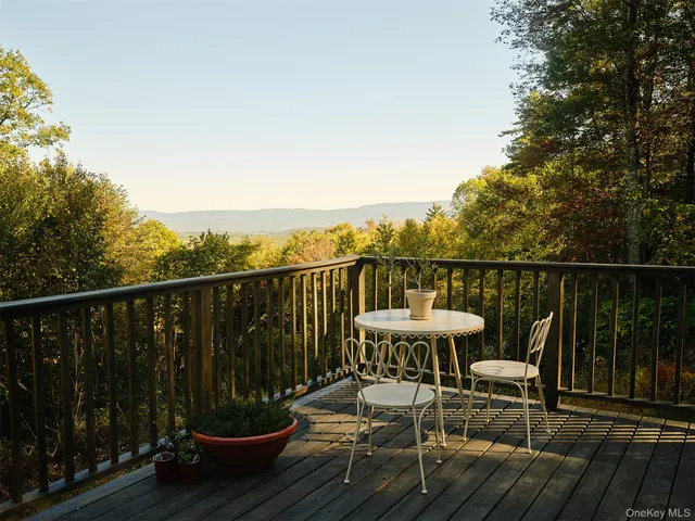 a view of a balcony with chairs and wooden floor