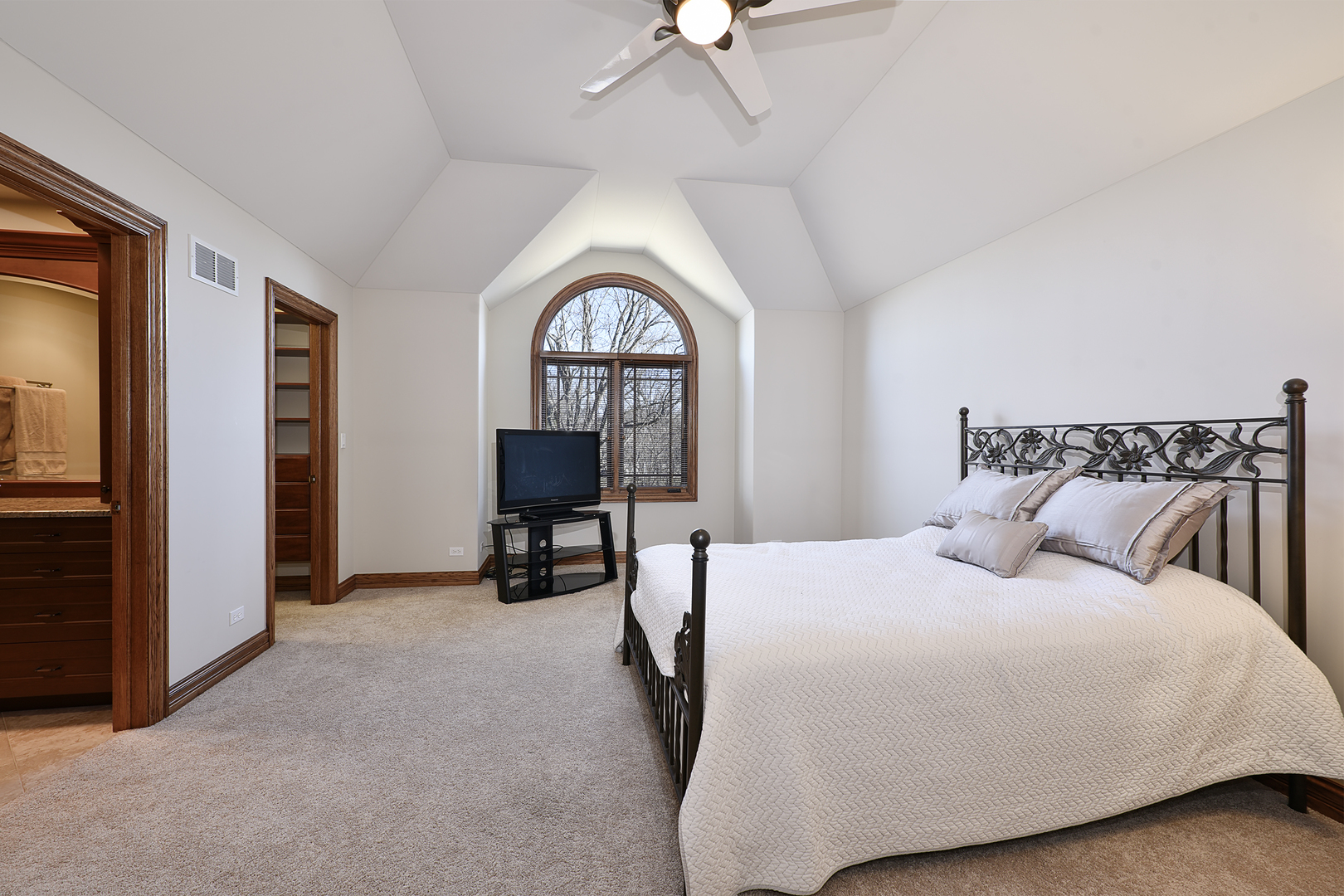 10 Carnoustie Lane Inverness, IL 60067 - Photo 20 of 44 a bedroom with a bed a table and a chandelier