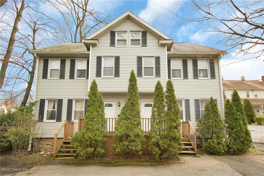 25 Valley Road, Unit 25 Cos Cob, CT 06807 - Photo 2 of 17 a view of a white house with large windows and a small yard