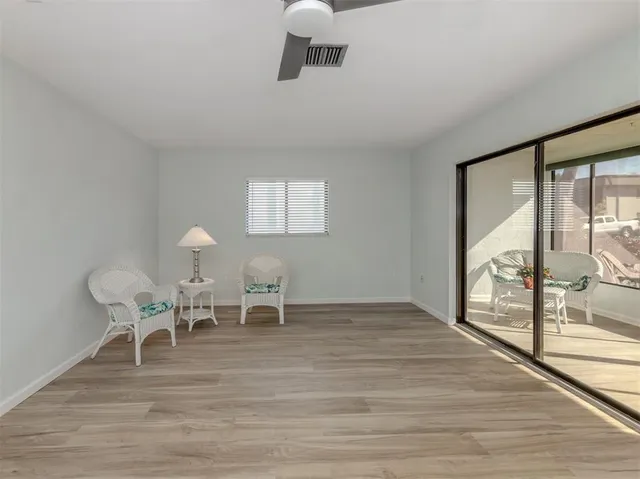 a living room with furniture a table and wooden floor