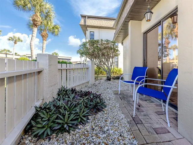 a backyard of a house with table and chairs potted plants