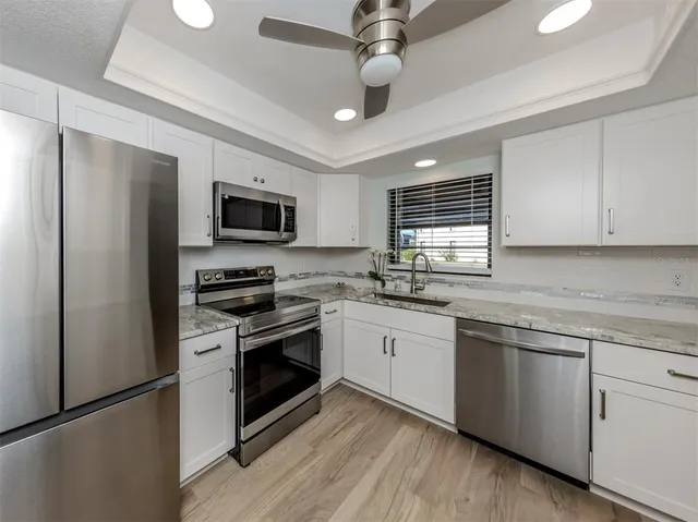 a kitchen with stainless steel appliances granite countertop a stove cabinets and a refrigerator
