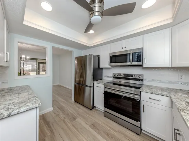 a kitchen with stainless steel appliances granite countertop a stove microwave and refrigerator