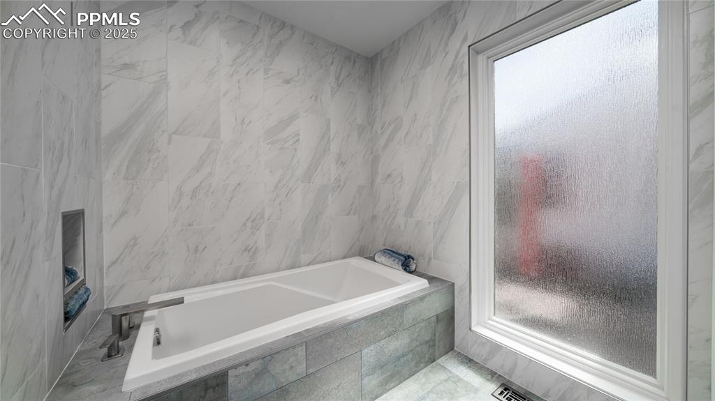 7550 Dairy Ranch Road Colorado Springs, CO 80919 - Photo 17 of 39 a bathroom with a bathtub and a shower