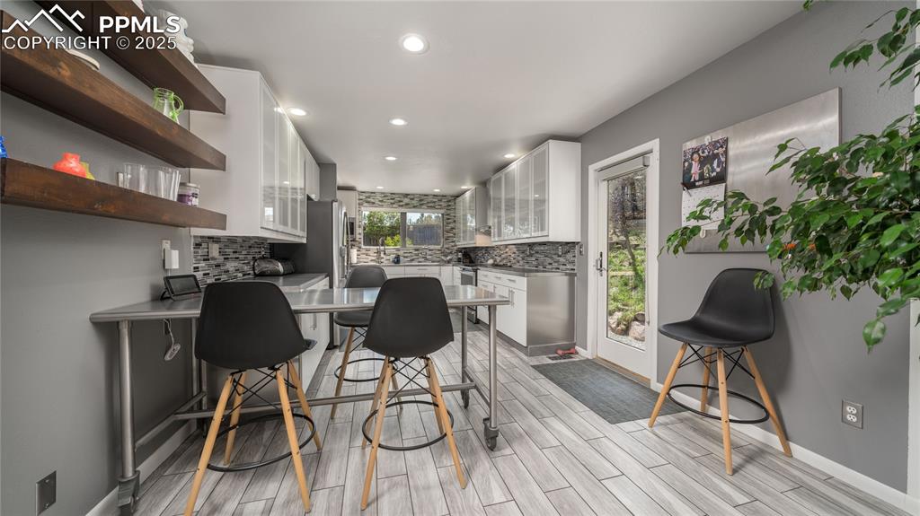 7550 Dairy Ranch Road Colorado Springs, CO 80919 - Photo 9 of 39 a kitchen with stainless steel appliances granite countertop a table and chairs in it