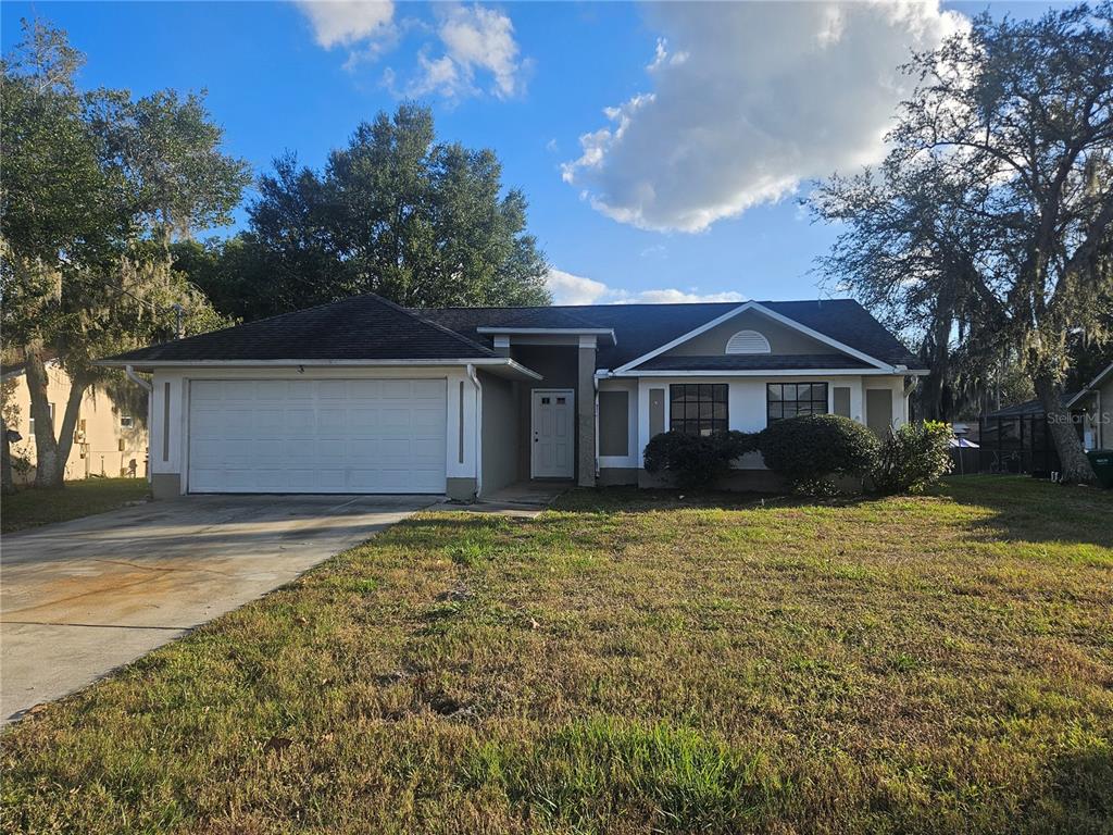a front view of house with yard and trees in the background