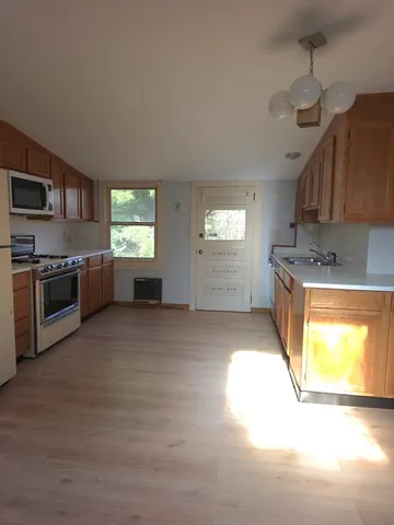 a kitchen with stainless steel appliances granite countertop a stove a sink and a microwave