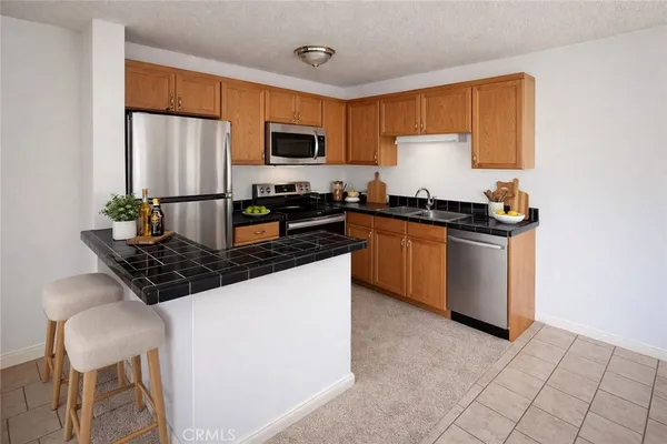 a kitchen with granite countertop a sink a counter top space cabinets stainless steel appliances and cabinets