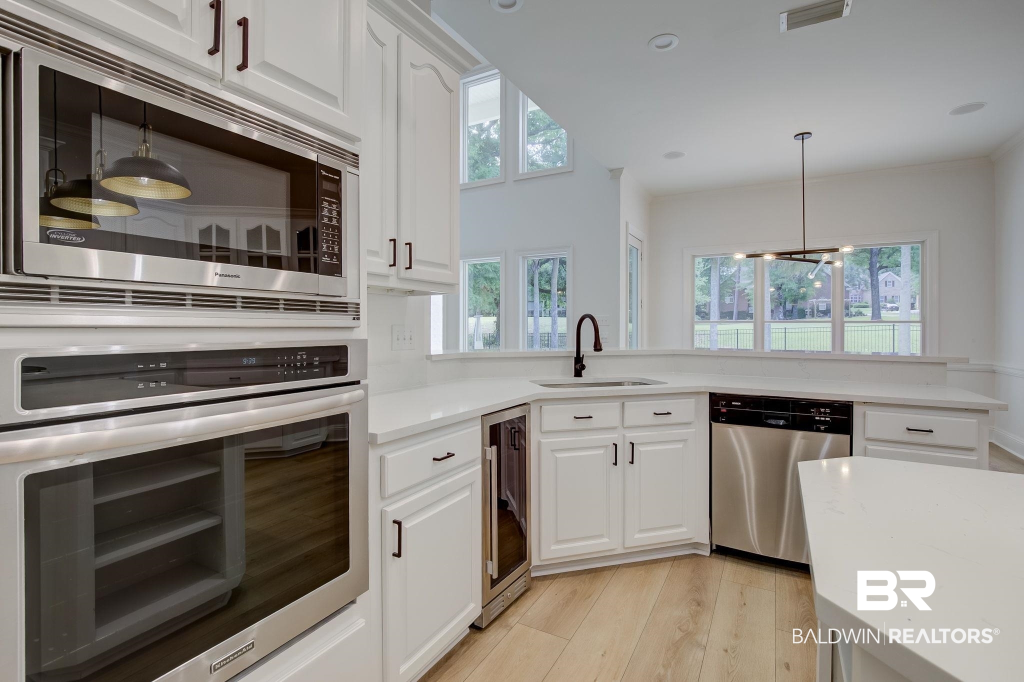 105 High Pines Ridge Fairhope, AL 36532 - Photo 29 of 97 Kitchen with appliances with stainless steel finishes, a sink, wine cooler, light wood-type flooring, and white cabinetry