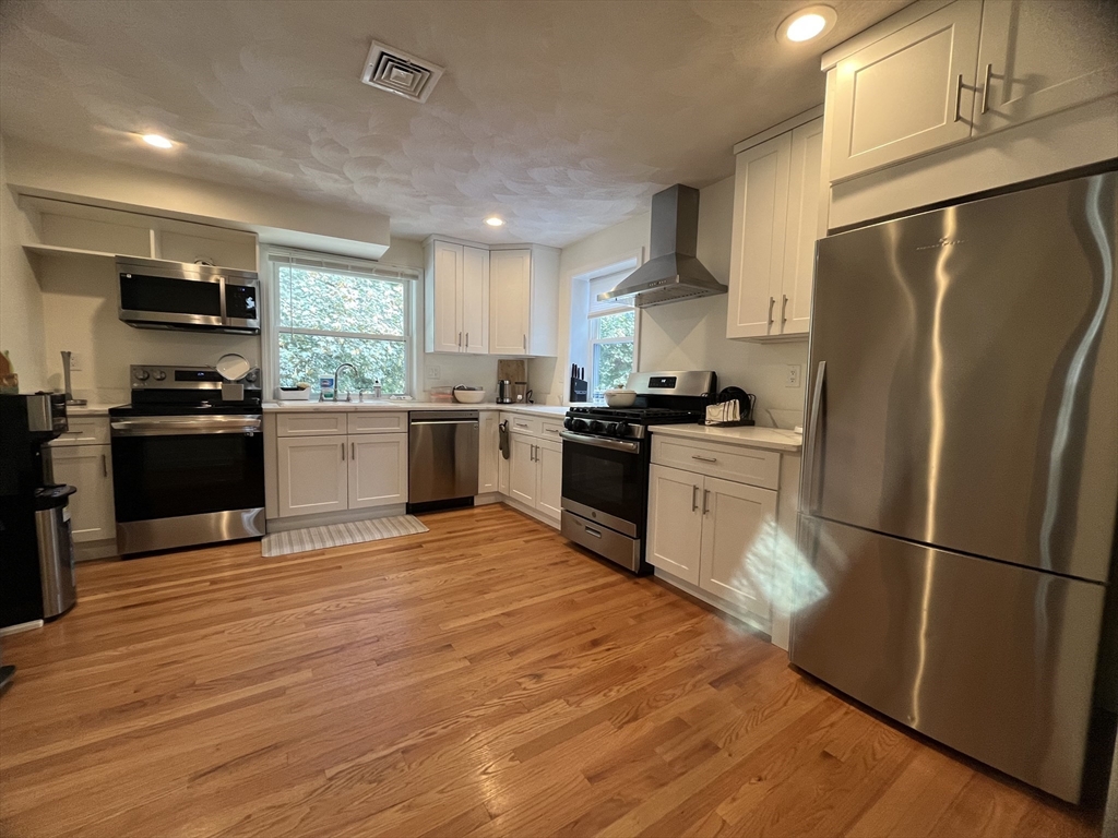 a kitchen with stainless steel appliances granite countertop a refrigerator stove and sink
