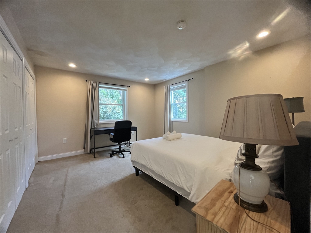 195 Grove Street, Unit 201 Cambridge, MA 02138 - Photo 11 of 20 a bed room with a bed and a lamp