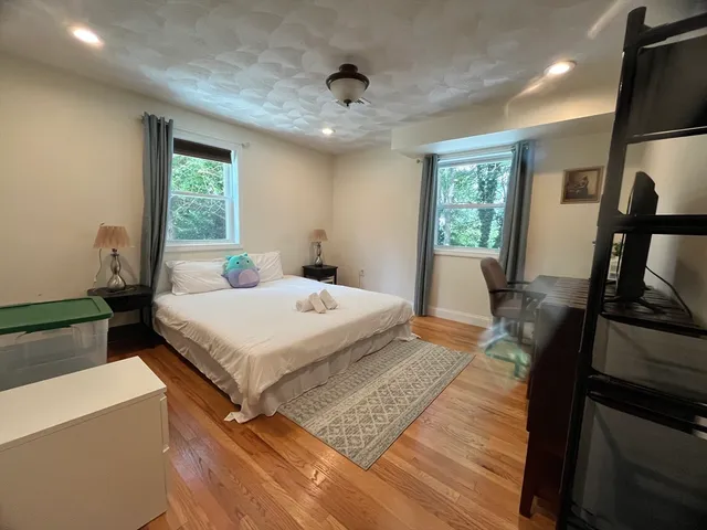 a bedroom with a bed and wooden floor
