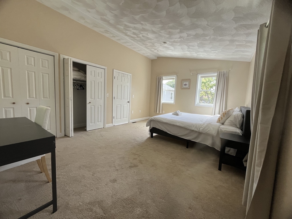 195 Grove Street, Unit 201 Cambridge, MA 02138 - Photo 8 of 20 a spacious bedroom with a bed and a window