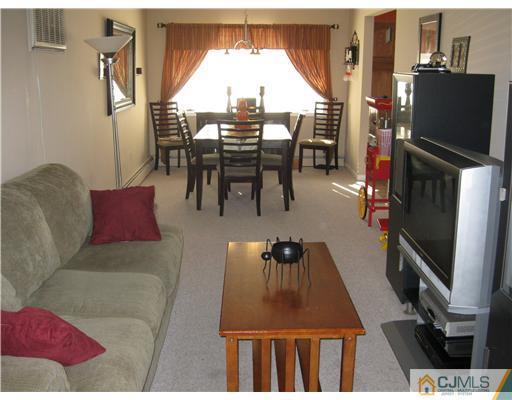 19 Baxter Road Edison, NJ 08817 - Photo 3 of 10 a living room with furniture a flat screen tv and a refrigerator