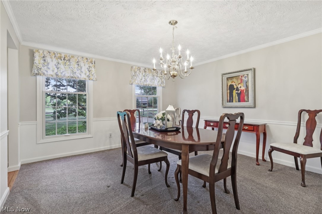 10253 Hoose Road Mentor, OH 44060 - Photo 3 of 30 Dining space featuring a healthy amount of sunlight, a chandelier, and crown molding