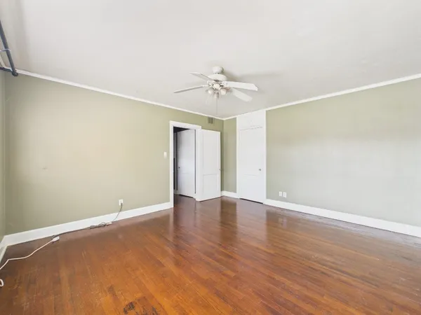 a view of an empty room with a window and wooden floor