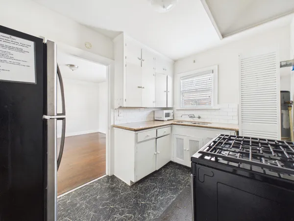 a kitchen with granite countertop a sink stove and cabinets