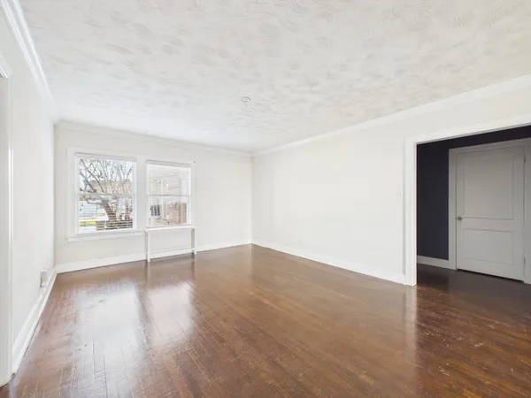 an empty room with wooden floor & closet