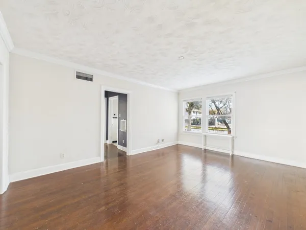 a view of a room with wooden floor and white walls