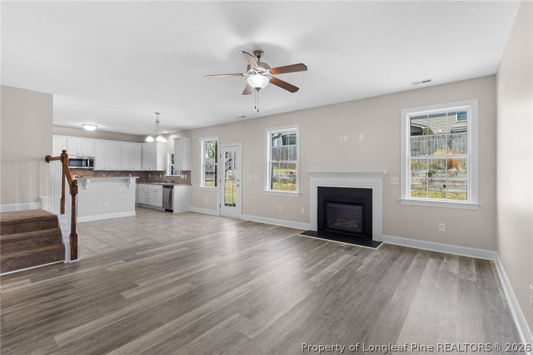 50 Huzzas Circle Cameron, NC 28326 - Photo 10 of 39 a view of a livingroom with a fireplace a ceiling fan and windows