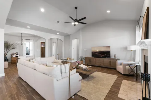 a view of a kitchen with kitchen island stainless steel appliances a sink and wooden floor