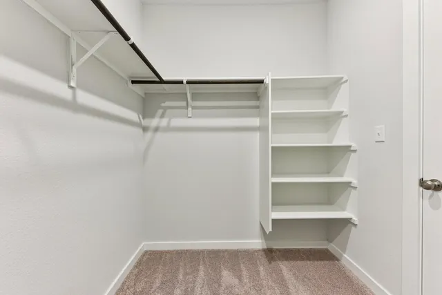 a view of walk in closet with empty racks