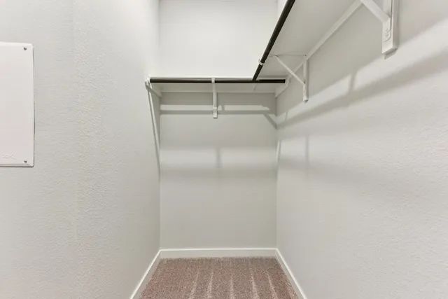a view of walk in closet with empty racks