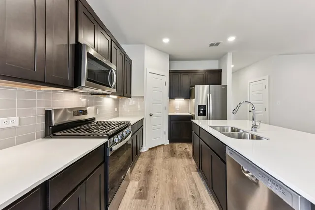 a kitchen with stainless steel appliances granite countertop a sink stove microwave and cabinets