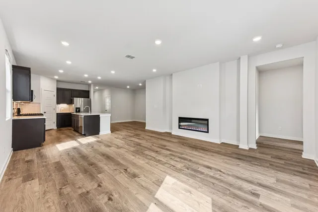 a view of kitchen with kitchen island granite countertop a stove top oven a sink and dishwasher with wooden floor