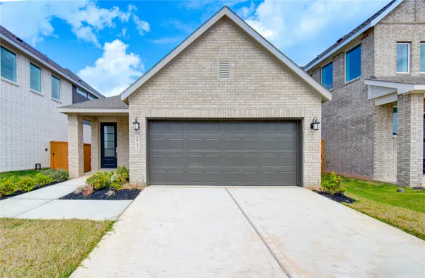 a front view of house along with garage and yard