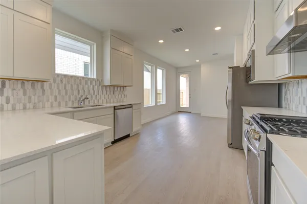 a kitchen with kitchen island a stove a sink and a refrigerator