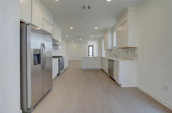 a view of kitchen with refrigerator and window